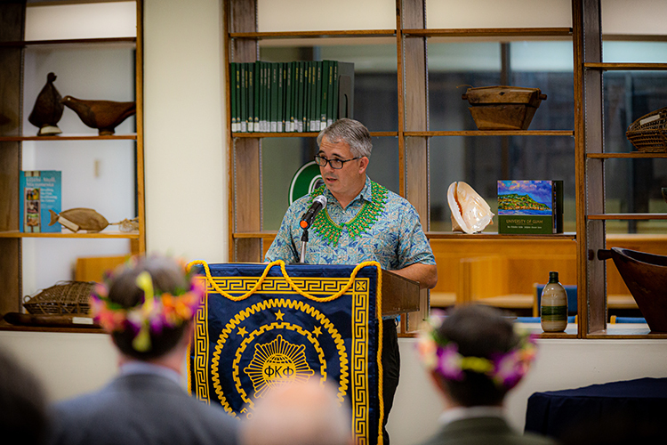 Troy McVey speaks as the first president of UoG Phi Kappa Phi chapter