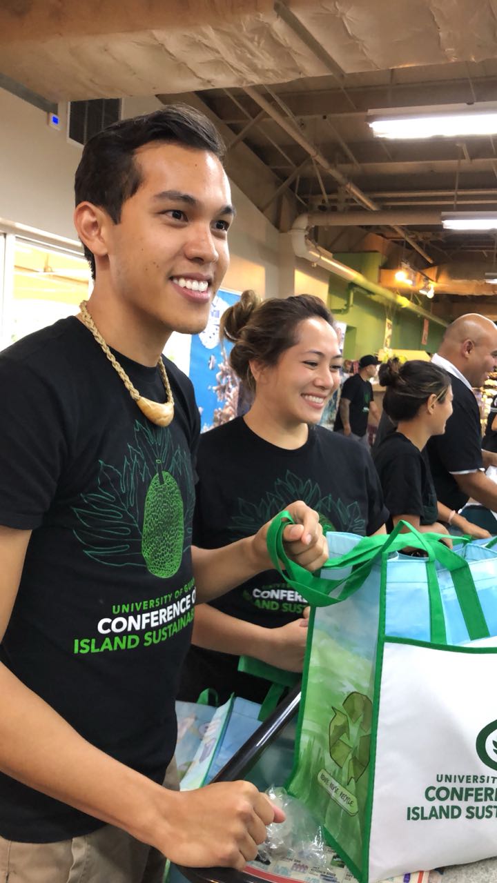 University of Guam Center for Island Sustainability (CIS) Sustainability Coordinator Phil Cruz and UOG Sea Grant Extension Associate Tatiana Perez prepare a free reusable bag for a customer on June 8 at Pay-Less Supermarket in Dededo. CIS provided 500 free reusable bags in total to customers in the two days following the enactment of Public Law 34-110 banning plastic bags.
