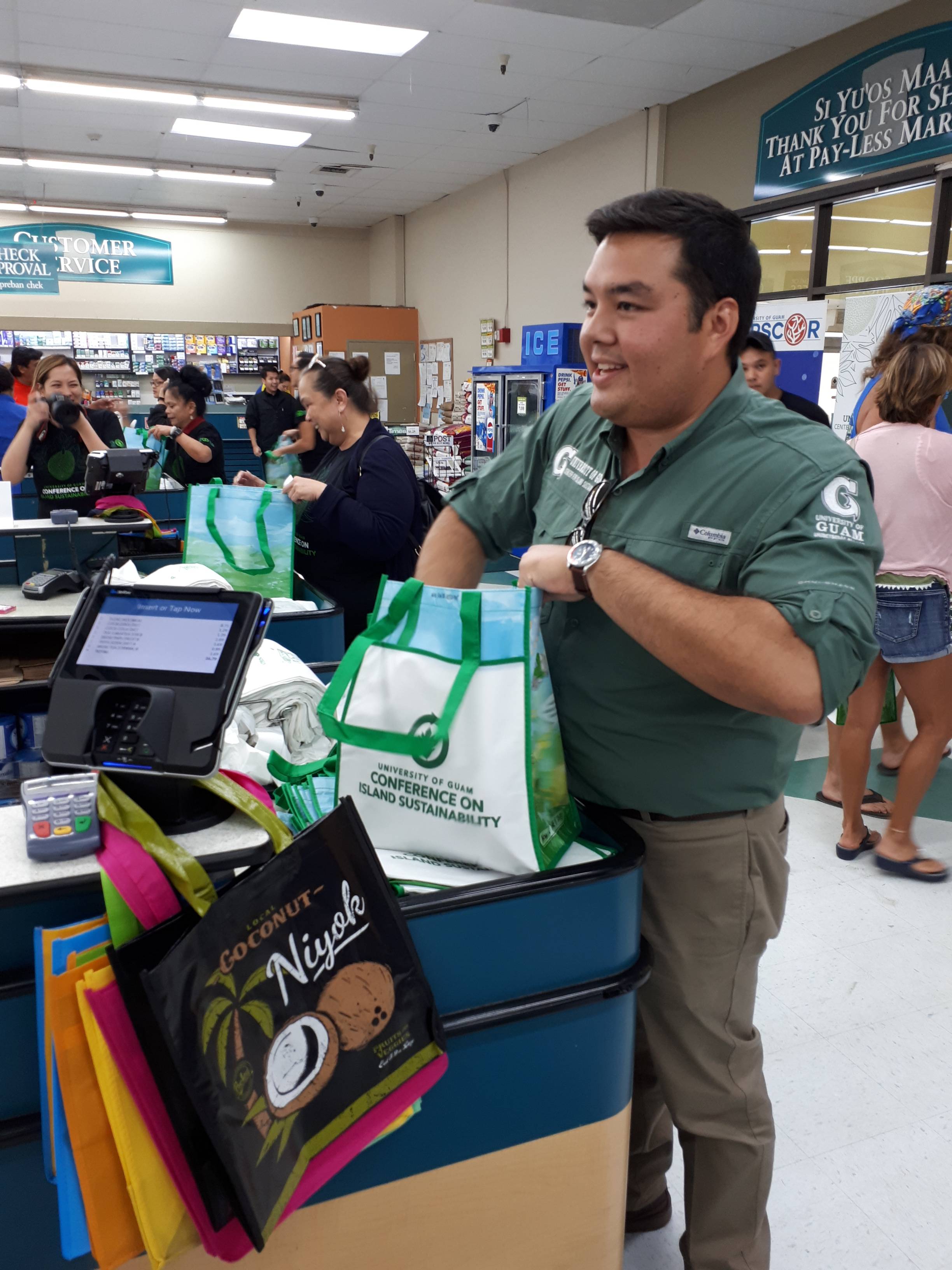 University of Guam Center for Island Sustainability (CIS) Executive Director Austin Shelton bags groceries in a free reusable bag for a customer on June 7 at the Agana Shopping Center Pay-Less Supermarket. CIS provided 500 free reusable bags in total to customers in the two days following the enactment of Public Law 34-110 banning plastic bags.