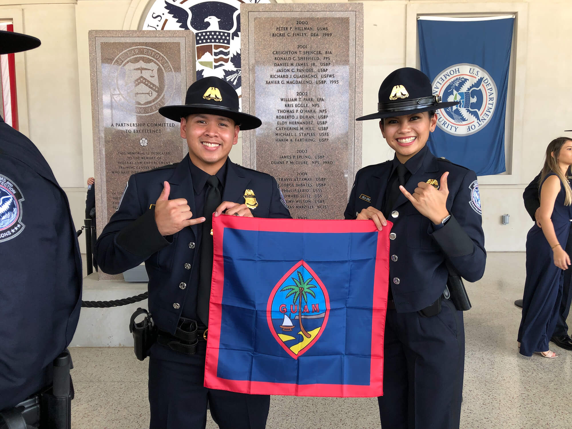 Kimberly Dela Cruz holds the Guam flag with fellow CBP graduate Roy Eay Jr. from Guam.