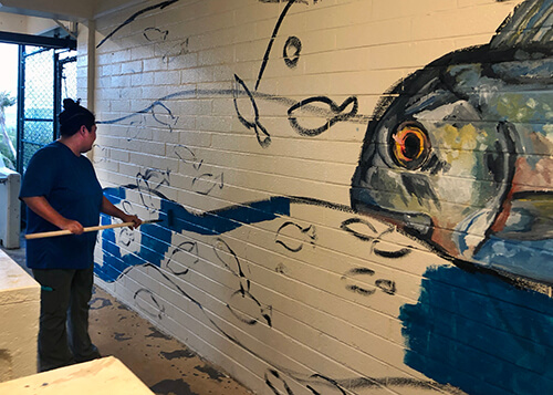 Micronesian studies graduate student Nina Peck works on an ocean-themed mural for the Marine Lab.