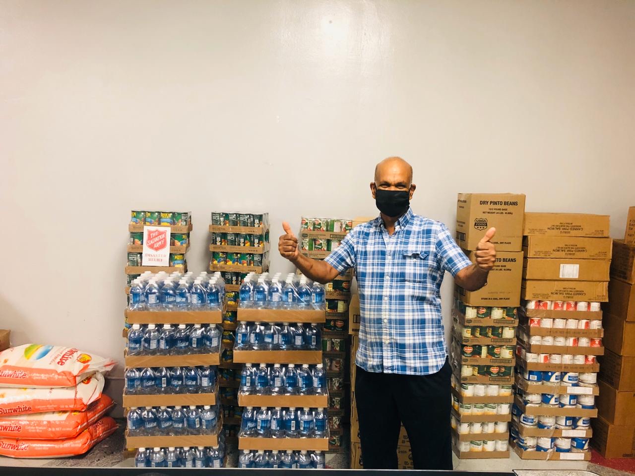 Thiruchelvam “Thiro” Vadivel stands by boxes of donated food items.