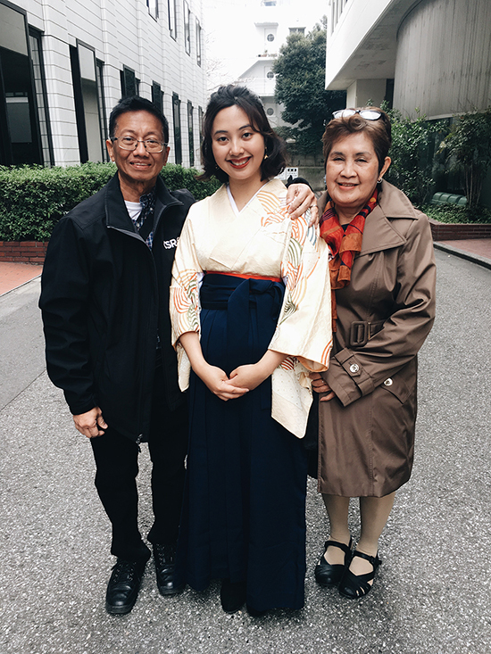 Tuazon wearing traditional graduation attire with her parents in Tokyo.
