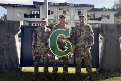 Three UOG ROTC cadets pose for a picture in front of ROTC building