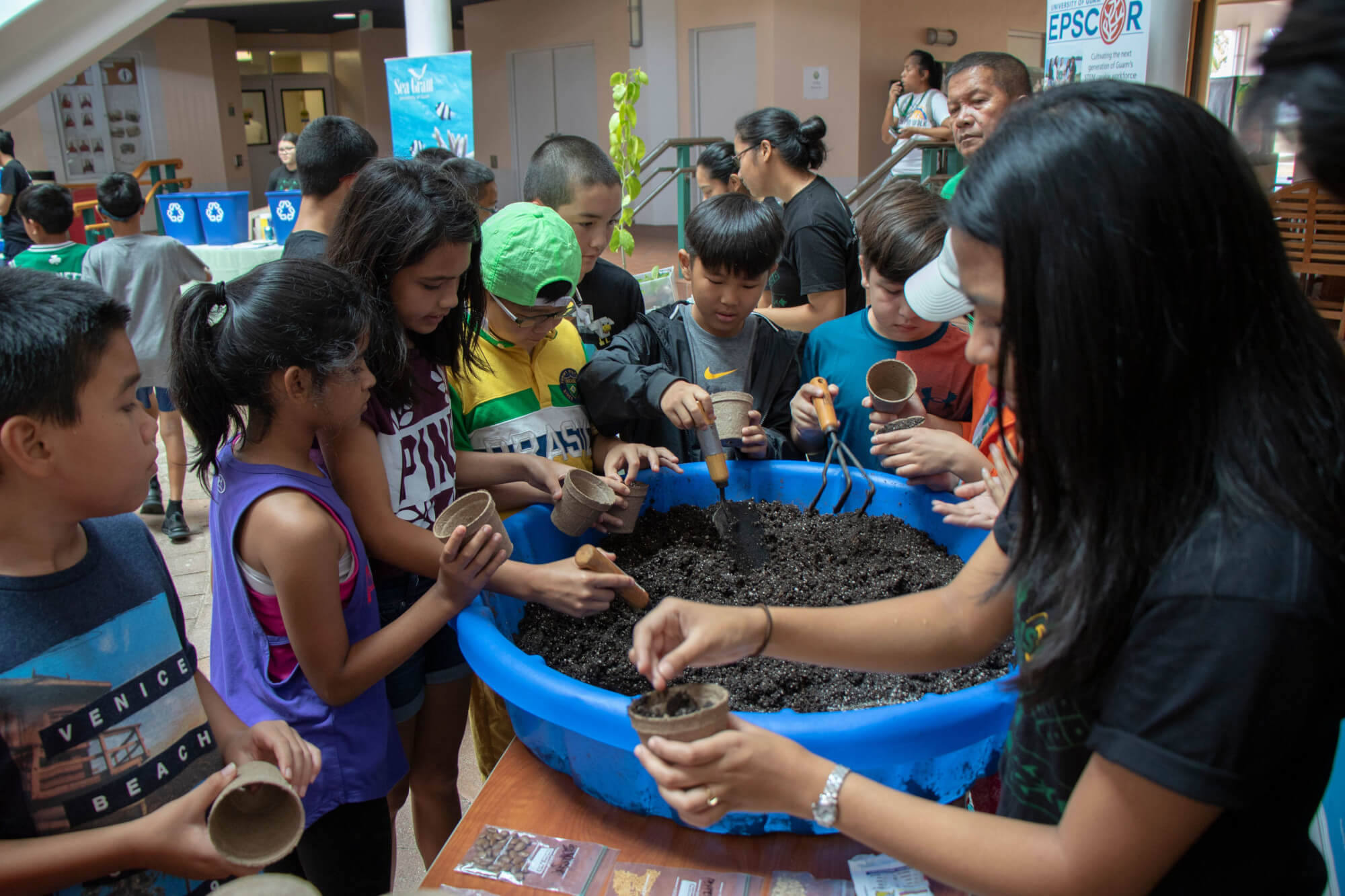 Nicole Imamura provides a demonstration on potting plants to children