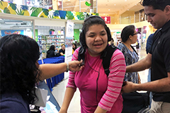 A CEDDERS staff member from UOG assists Jecilla Cruz trying out the SubPac