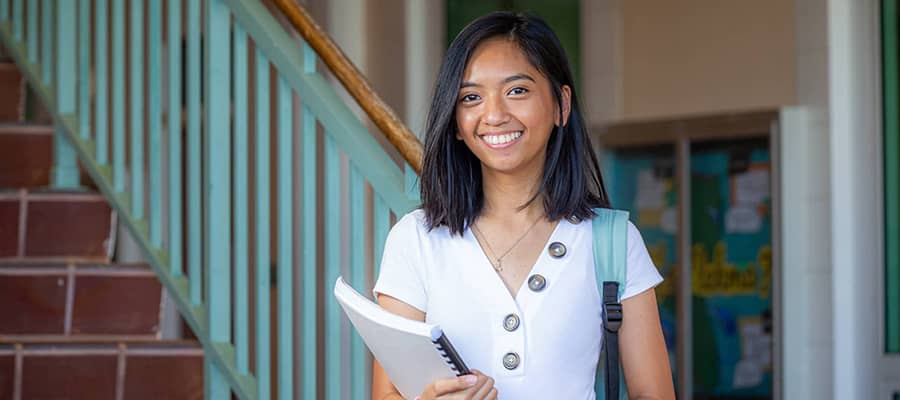 Photo of a Triton female student holding a book