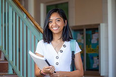 Photo of a Triton student holder a book