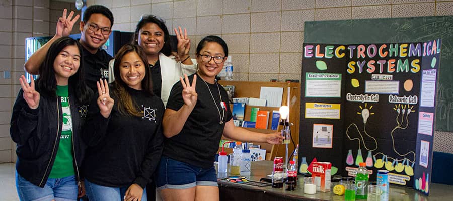 A group photo of Tritons alongside with a science project