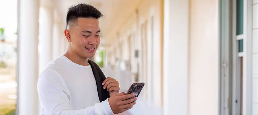 Photo of a male student using a phone to schedule classes