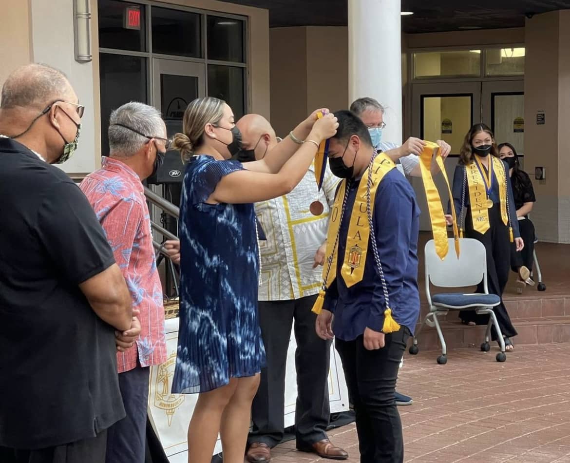 Sen. Amanda Shelton places medal on graduating senior Cullen Pinaula.