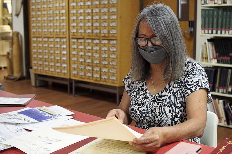 Photo of Debbie Torres looking through copies of documents