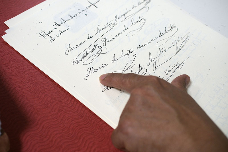 Photo of Debbie Torres pointing to the signature of her great-grandfather’s sister