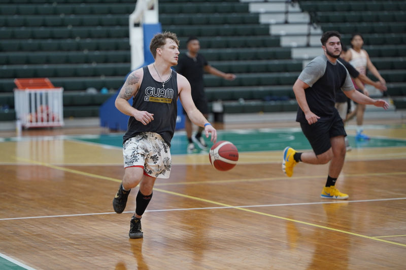 Logan Hopkins, left, dribbles the ball up the court at the Triton Men's Basketball Team tryouts 