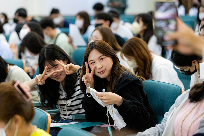 College students smile for the camera during an orientation ceremony