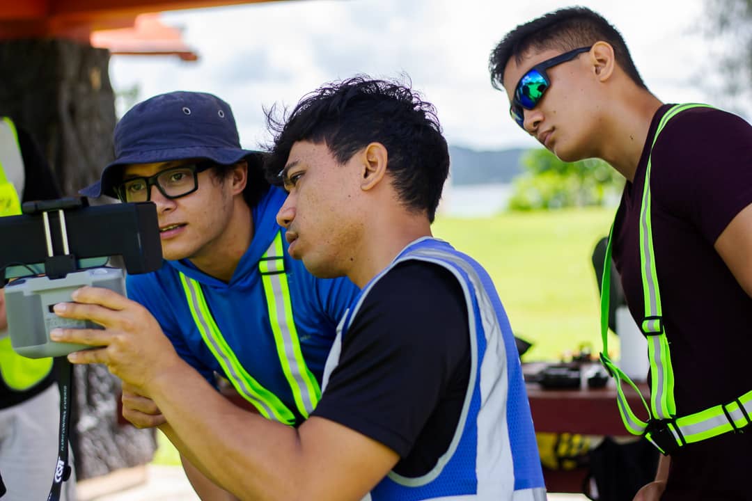 Photo of UOG Drone Corps members Francisco Camacho and Javier Garrido observe as Bella Wings Aviation instructor Michael Quitugua