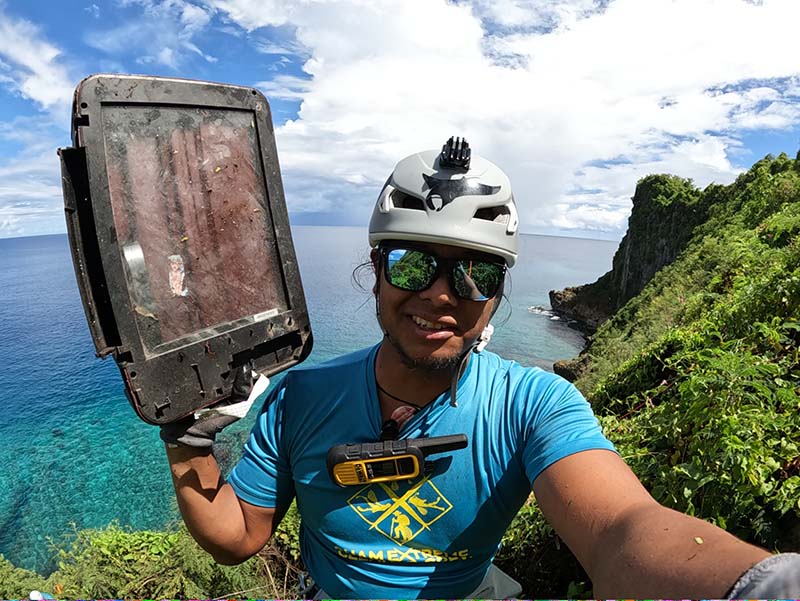 Farron Taijeron takes a video of himself picking up dumped electronics at Oka Point.