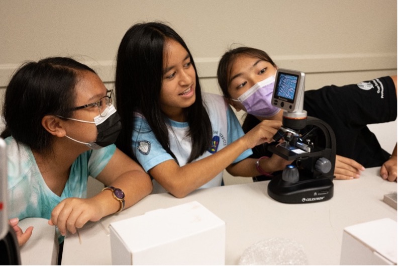 4-H campers look at a microscope 