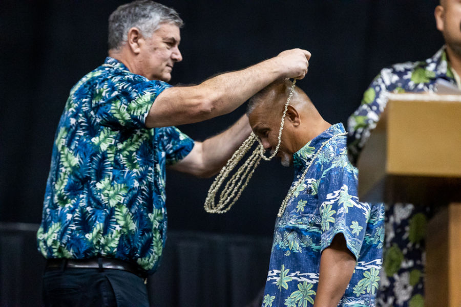 Senior Vice President for Finance Randall Wiegand puts a lei on Supervisor of the Year Carlos R. Taitano, Director of Global Learning and Engagement.