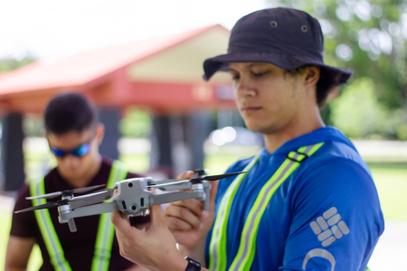 Drone Corps cohort, examines a drone 