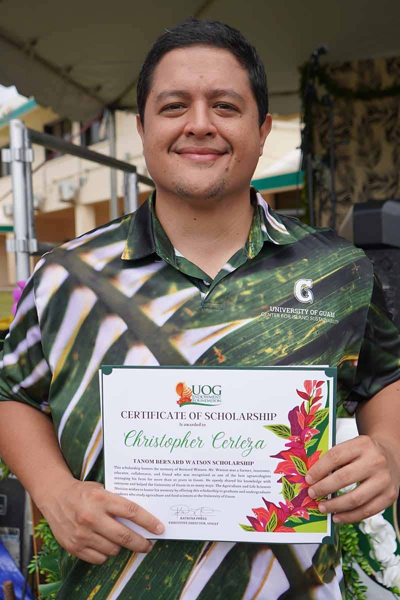 Christopher Certeza poses for a photo with his scholarship award certificate