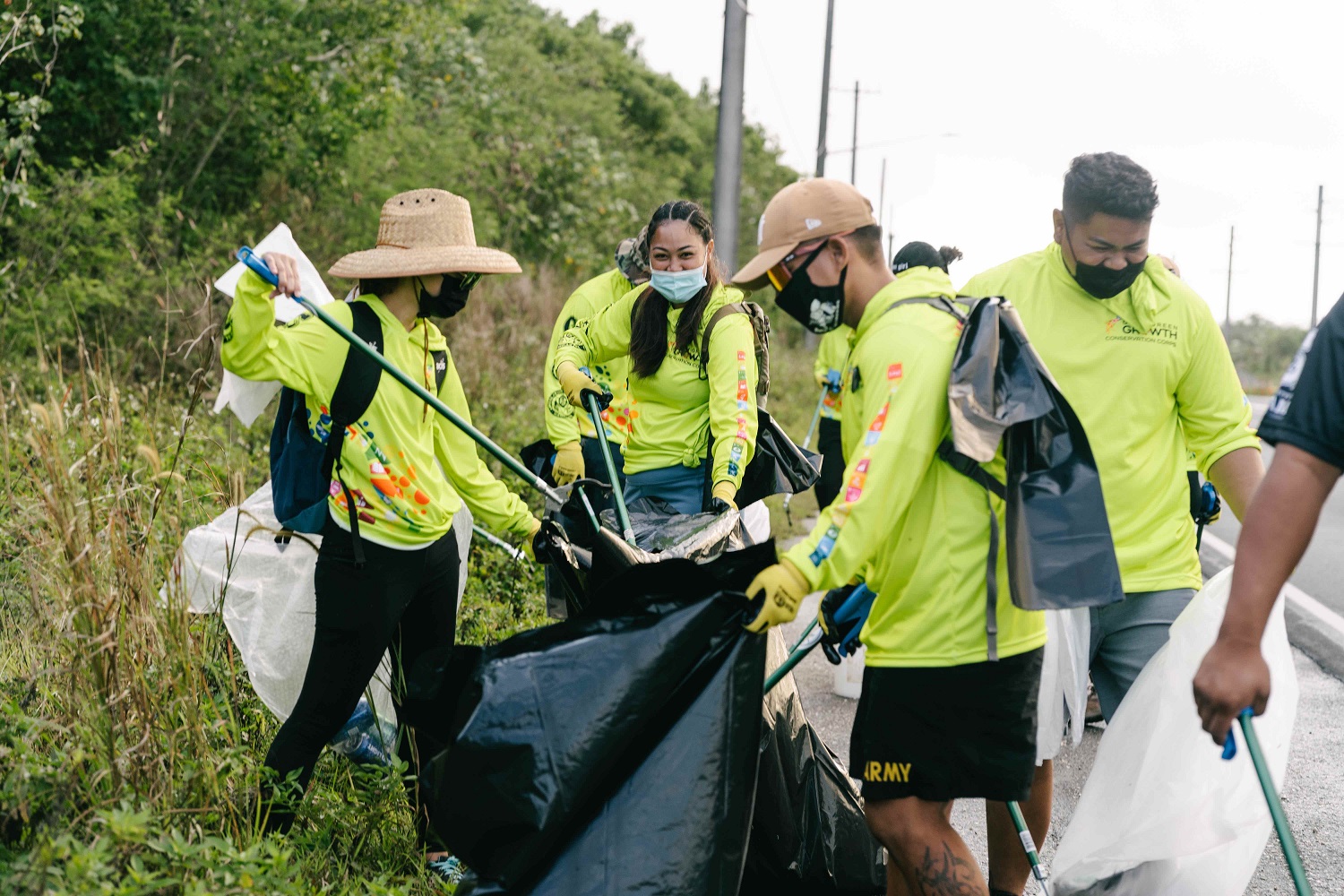Members of the Guam Green Growth Conservation Corps cleaning side of the streets.