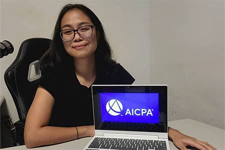 Jamabeva Masangkay poses for a photo with AICPA photo on laptop