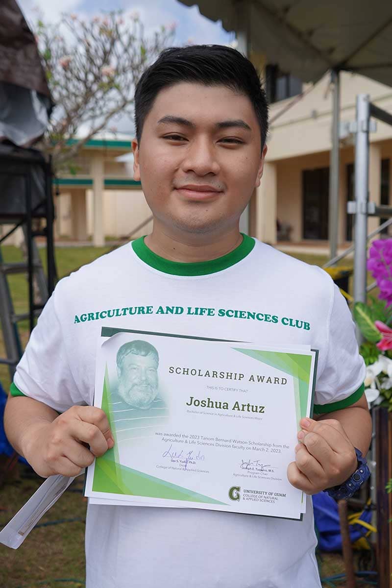 Joshua Artuz poses for a photo with his scholarship award certificate