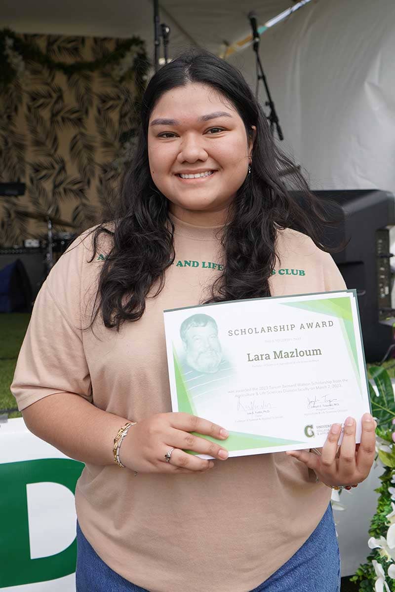 Lara Mazloum poses for a photo with her scholarship award certificate.