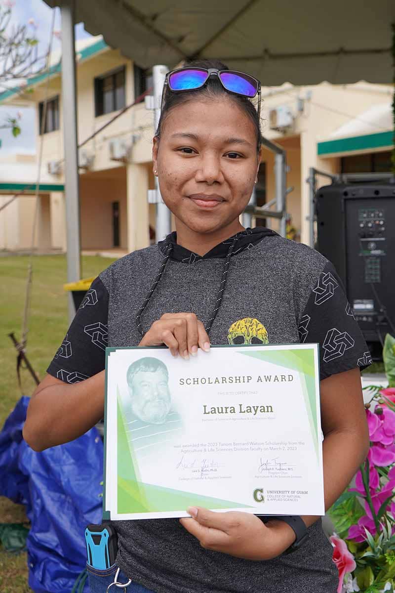 Laura Layan poses for a photo with her scholarship award certificate