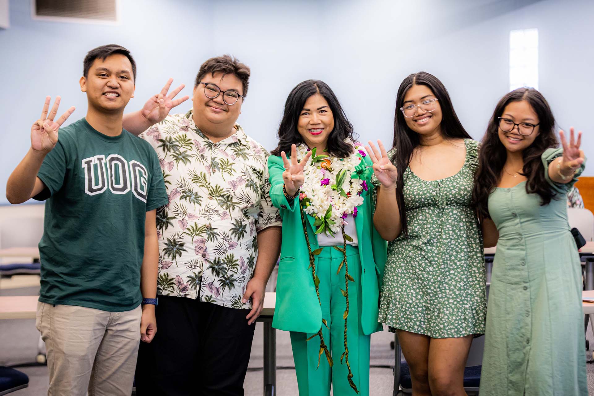 Dr. Anita Borja Enriquez, center, and members of the UOG Student Government Association show the Triton sign following the selection of Dr. Enriquez as the next UOG president.