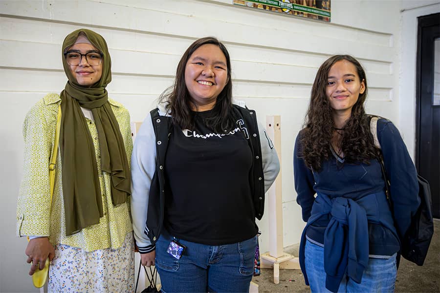 Three UOG students pose for a photo right outside the doors of the UOG Fieldhouse