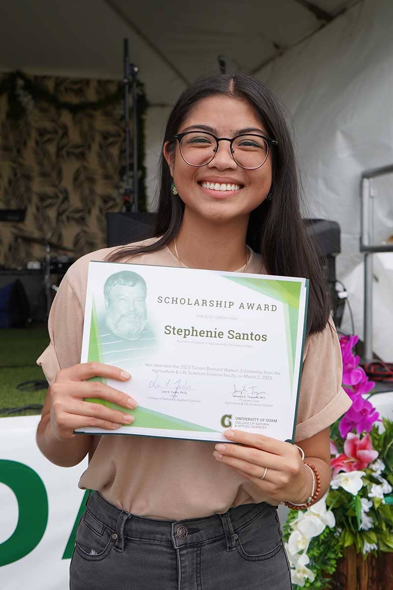 Stephenie Santos poses for a photo with her scholarship award certificate.