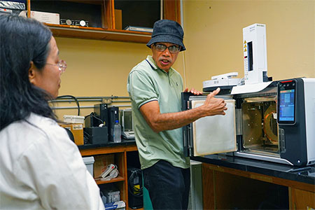 Dr. Maika Vuki teaches UOG chemistry faculty how to use the new gas chromatograph mass spectrometer.