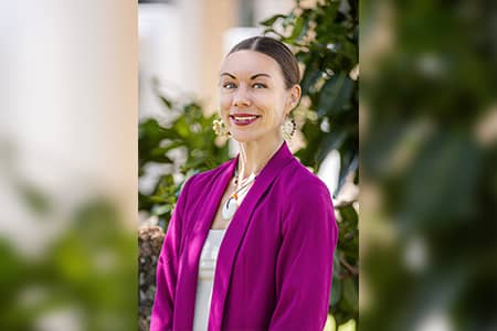 Victoria Leon Guerrero poses in front of some greenery for a photo