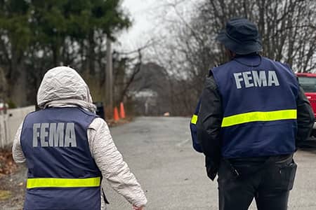 Two FEMA personnel walking during outreach