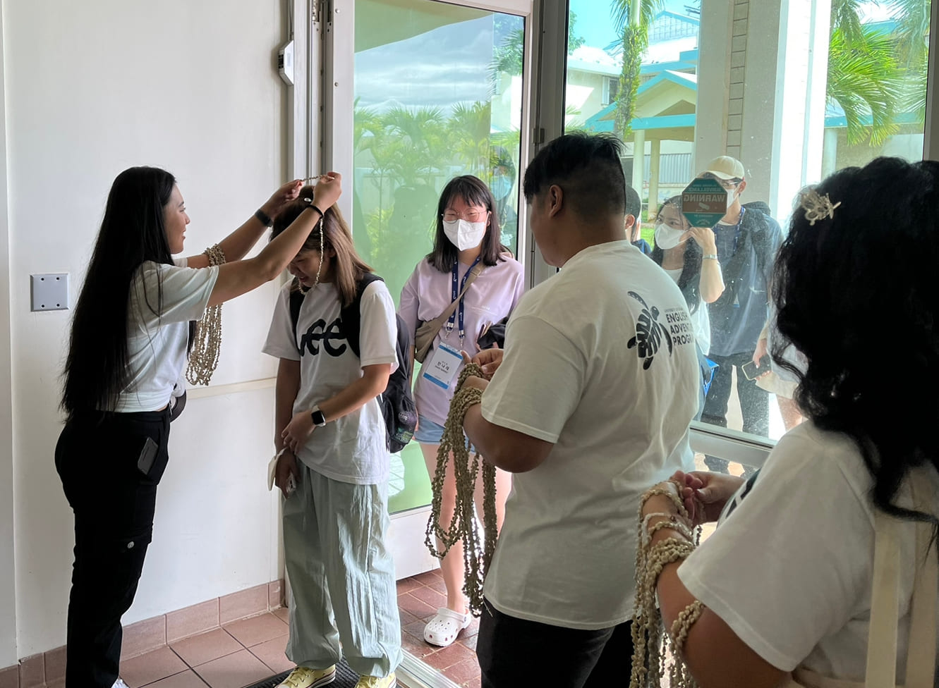 UOG English Adventure Program members giving out lays to international students.