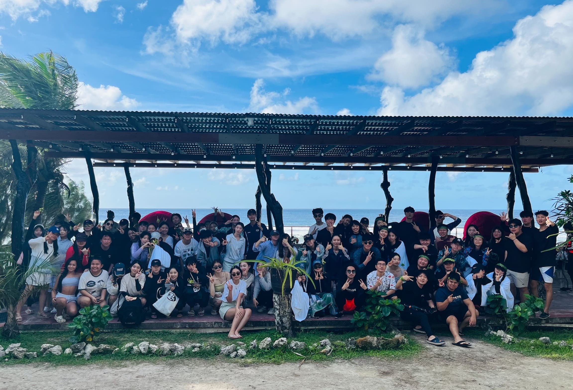 UOG English Adventure Program members at the beach taking a group photo with the international students.