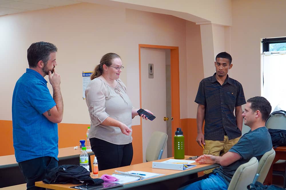 Photo of visiting NDCU animal science experts talking with regional farmers