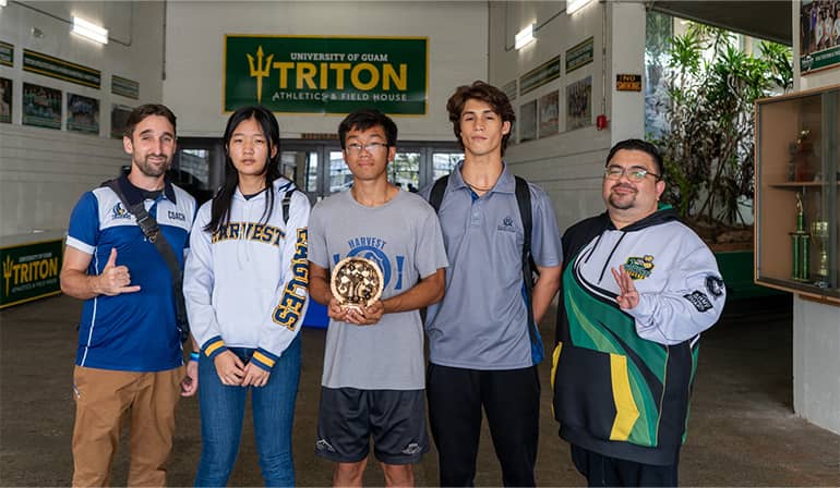 Harvest chess coach, students, and esports manager pose for a photo at Calvo Fieldhouse