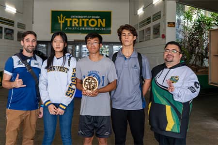 Harvest chess coach, students, and esports manager pose for a photo at Calvo Fieldhouse