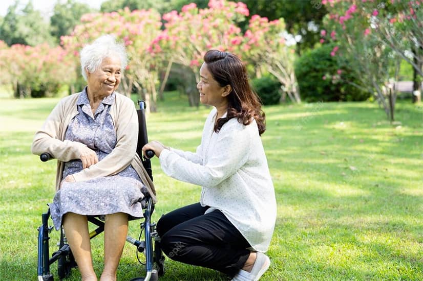 Social worker helps dementia patient in a wheelchair