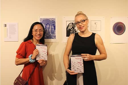 Joleen Unas poses with Dr. Irena Keckes in front of wall featuring her artwork “Amabie”