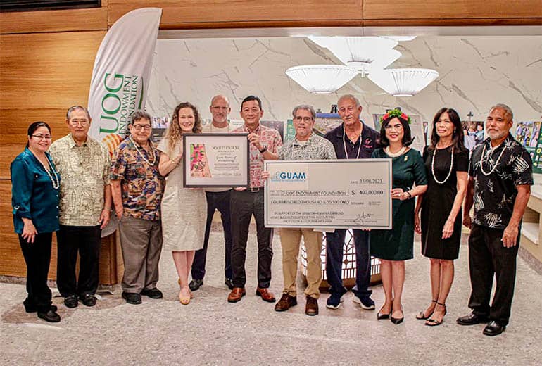 UOG President and members pose with UOG Endowment Foundation Members holding donation checks