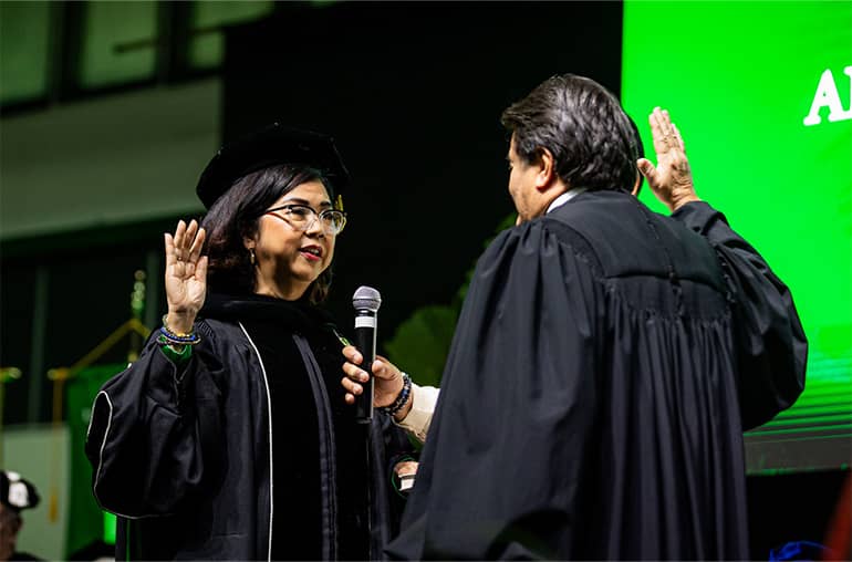 Dr. Anita Borja Enriquez is sworn in by Chief Justice Robert Torres at Calvo Field House
