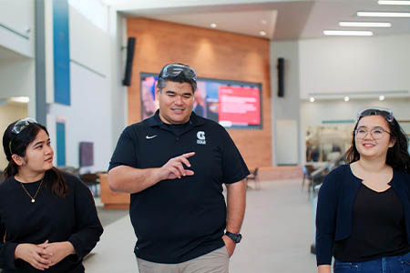 John Limtiacro walks with UOG engineering students at Pacific Northwest National Laboratory.