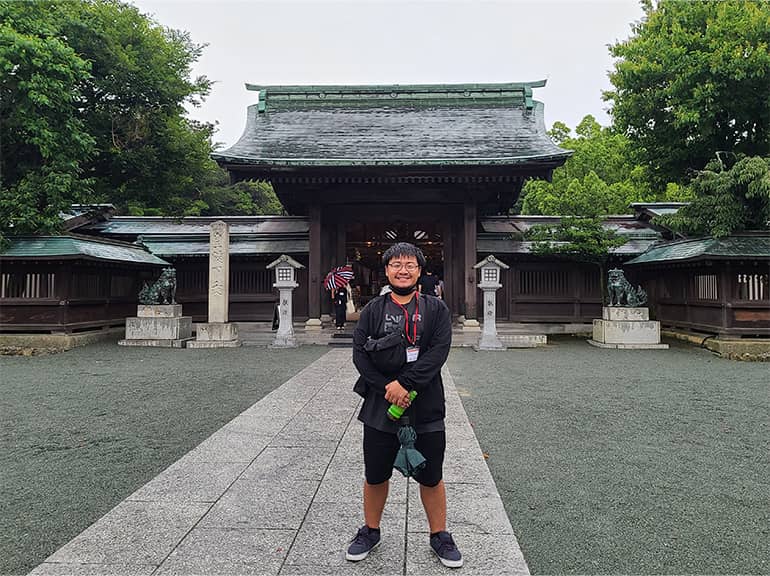 Raiki Ueda Leon Guerrero poses for a photo in Fukuoka with the Munakata Shrine in the background.