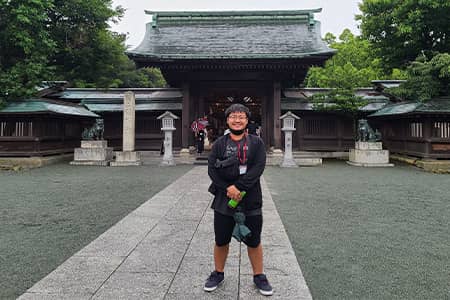 Raiki Ueda Leon Guerrero poses for a photo in Fukuoka with the Munakata Shrine in the background.