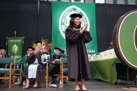 President Anita Borja Enriquez applauds the 319 graduates from the commencement stage.