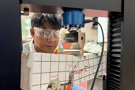 Dr. Ernesto J. Guades conducts a test on a concrete beam using a Universal Testing Machine (UTM)